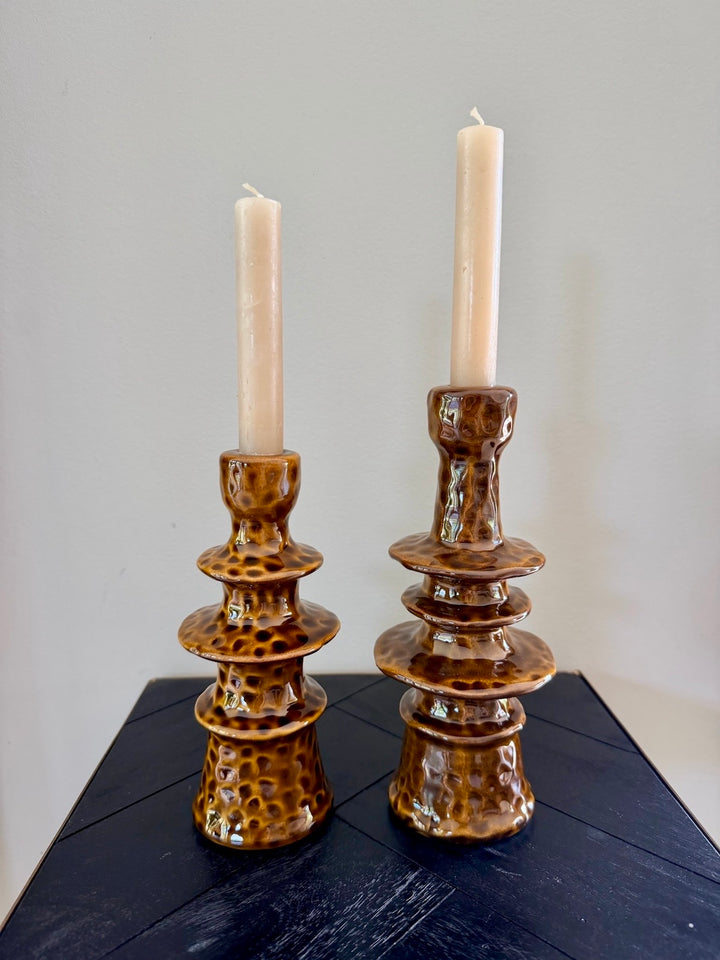 Twee bruine stoneware kandelaars Elara met dinerkaarsen in verschillende hoogtes