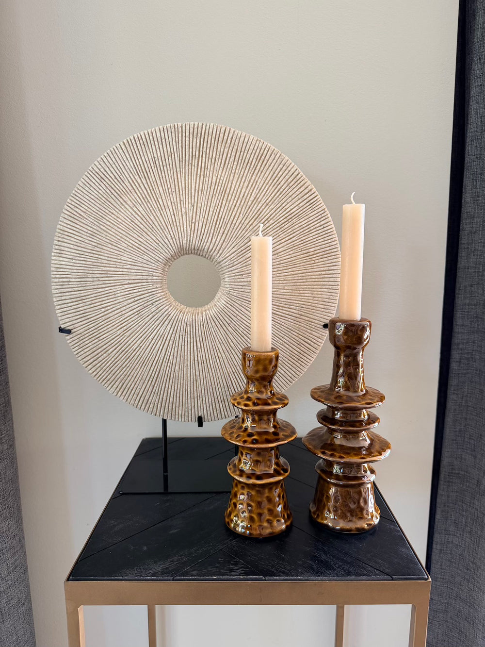 Zandstenen decoratie op standaard gecombineerd met twee bruine kandelaars