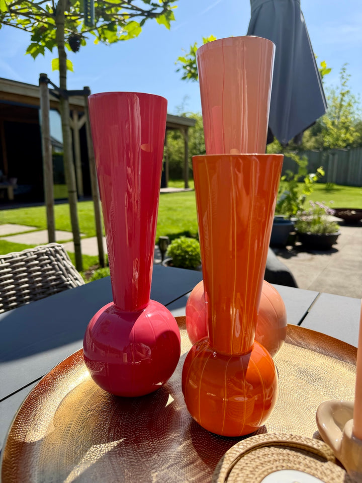 Roze en oranje TODI vazen op gouden decoratieschaal buiten