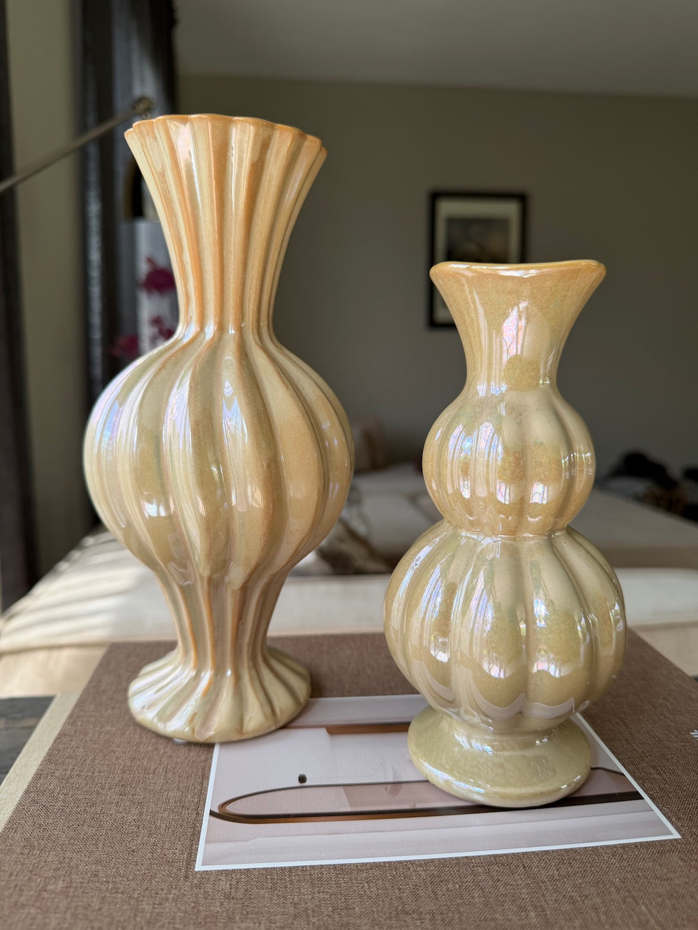 Beige keramieken vazen uit de Soft Glow Harmony decoratieset op luxe opbergboeken