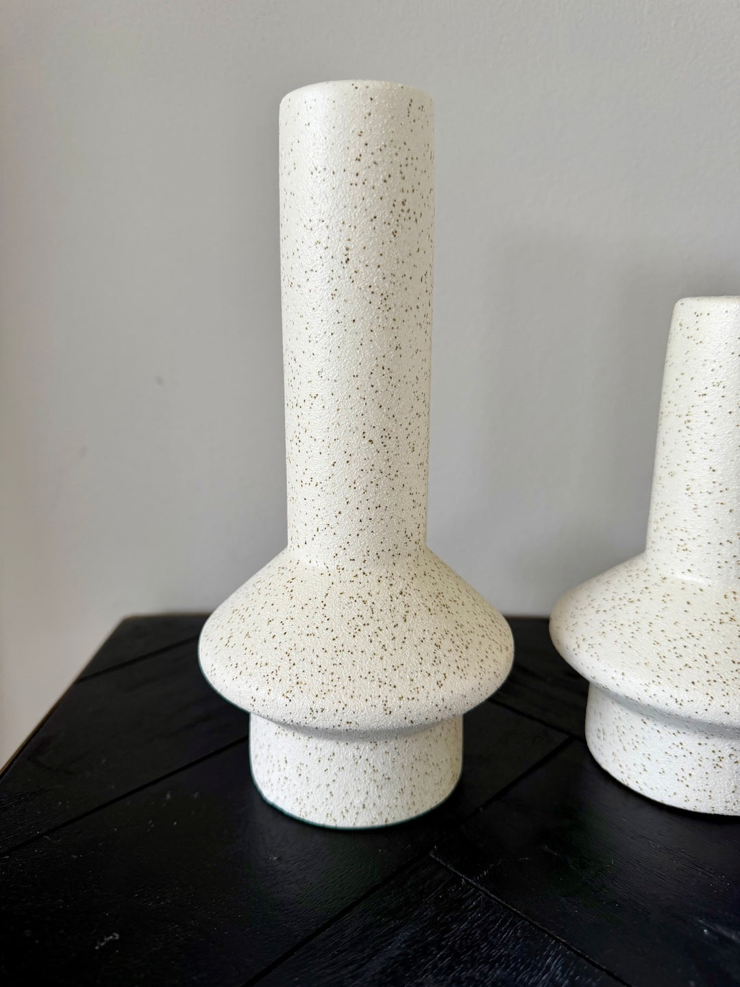 Detail van keramieken kandelaars in crème met gespikkelde structuur
