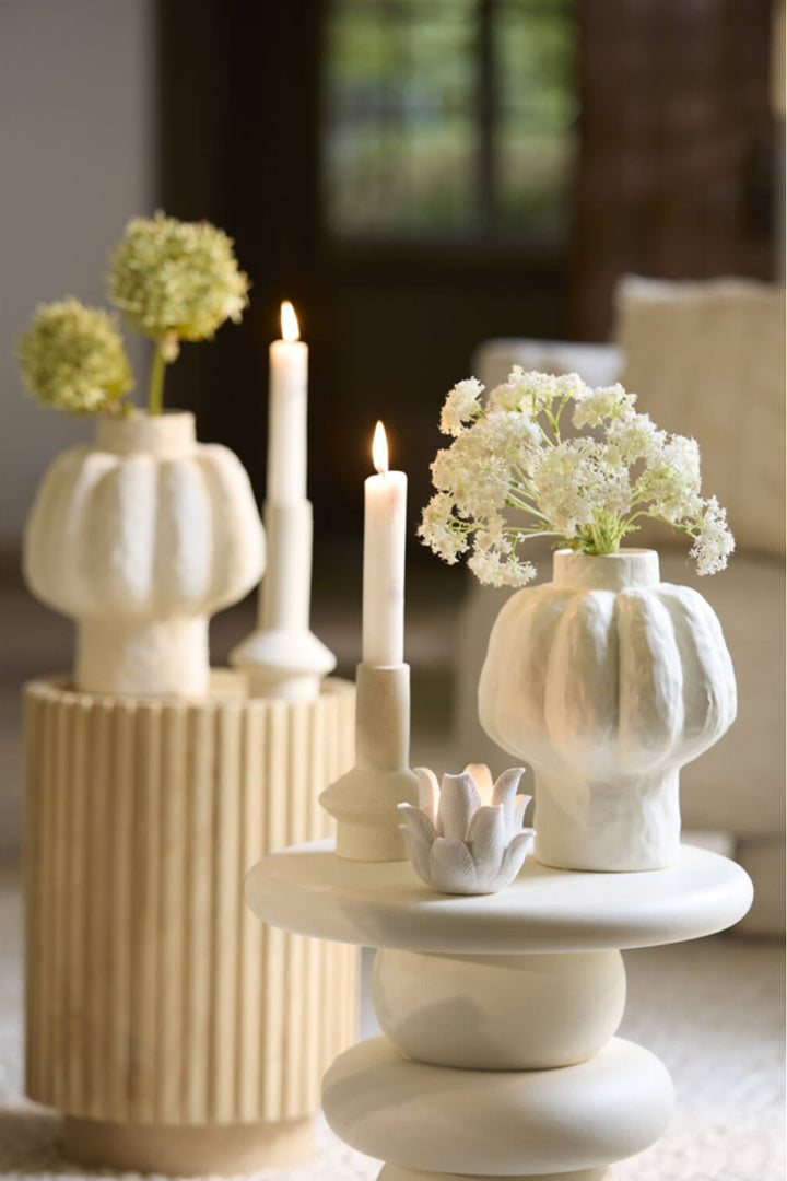 Sfeervolle styling met keramieken kandelaars en beige woondecoratie