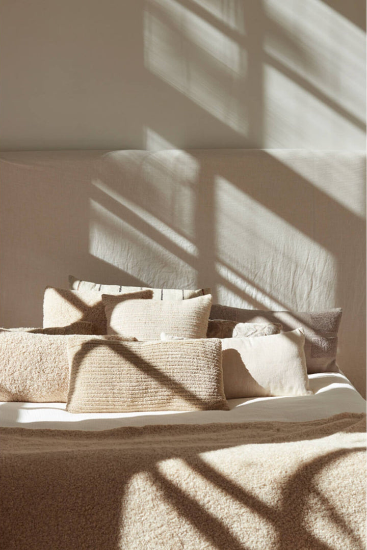 Langwerpig beige sierkussen op bank in rustige interieurstyling