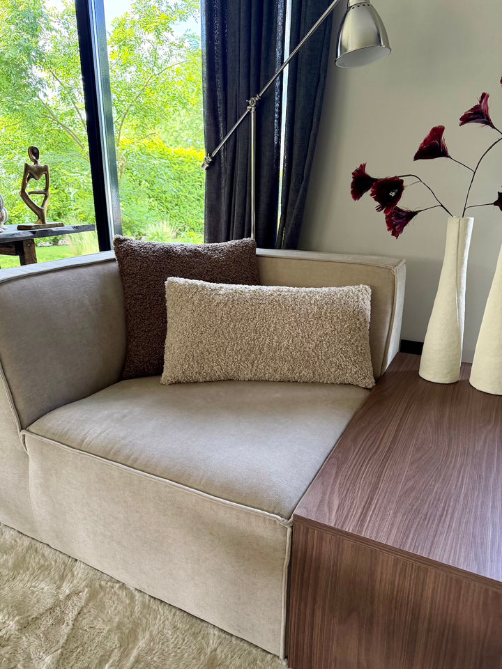 Beige sierkussen Lina Soft Beige op bank naast houten bijzettafel