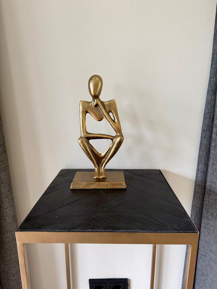 Abstract bronzen ornament van metaal gestyled op zwarte sidetable