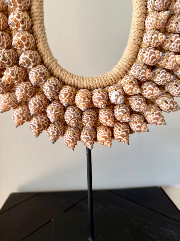 Close-up van schelpenketting op standaard met naturel touw en schelpen
