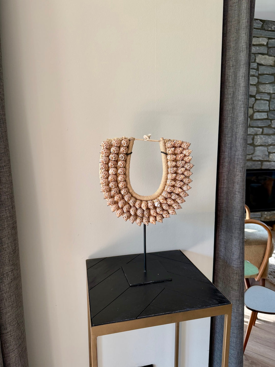 Schelpen ornament op zwarte standaard gestyled op bijzettafel in interieur