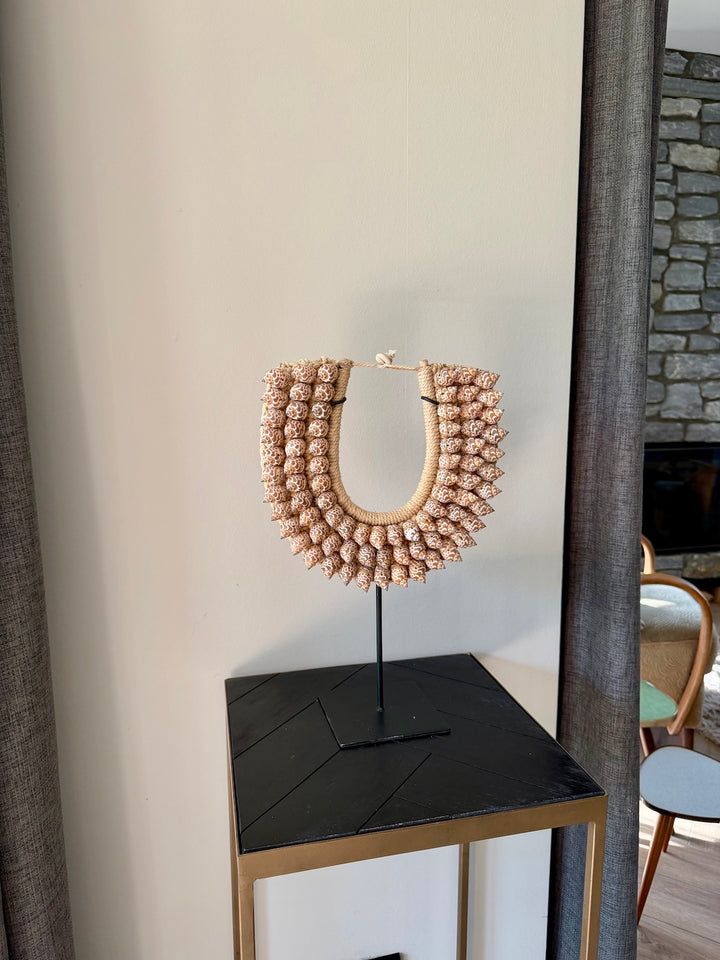 Schelpen ornament op zwarte standaard gestyled op bijzettafel in interieur
