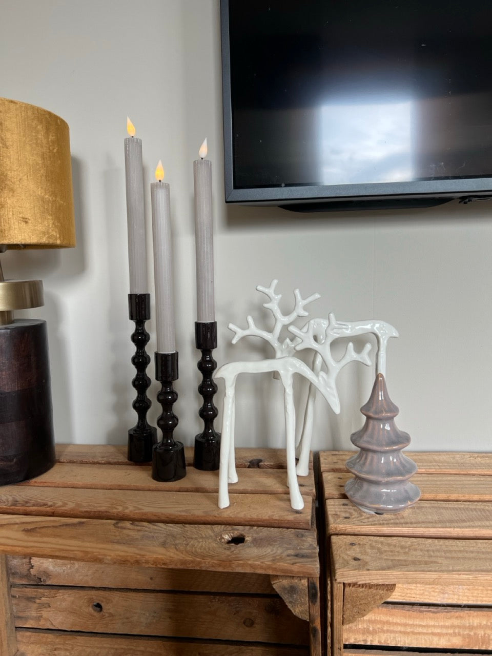 Witte glanzende rendieren gecombineerd met donkerbruine kandelaars – moderne kerststyling