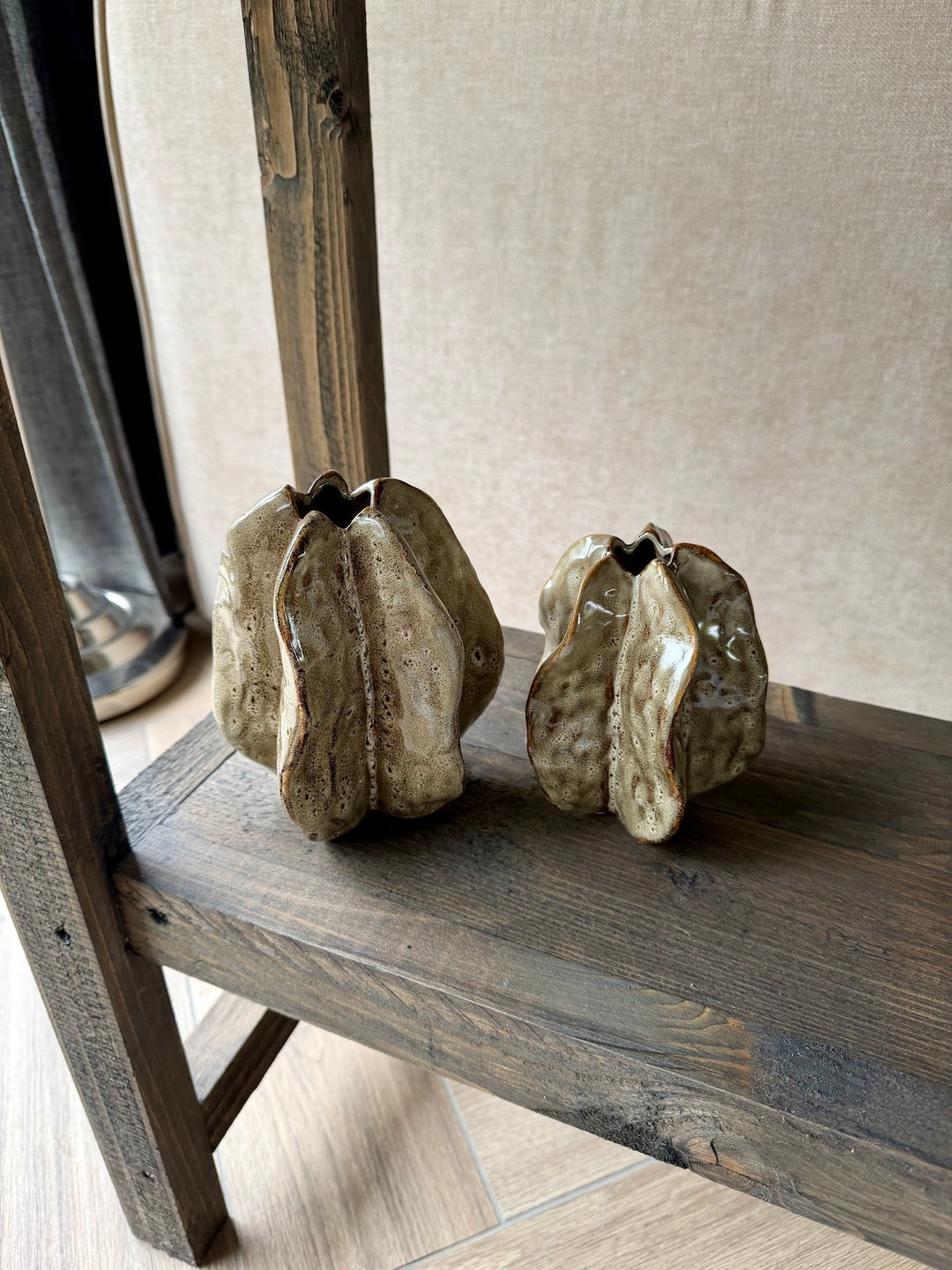 moderne woonaccessoires set in natuurlijke tinten op houten wandplank