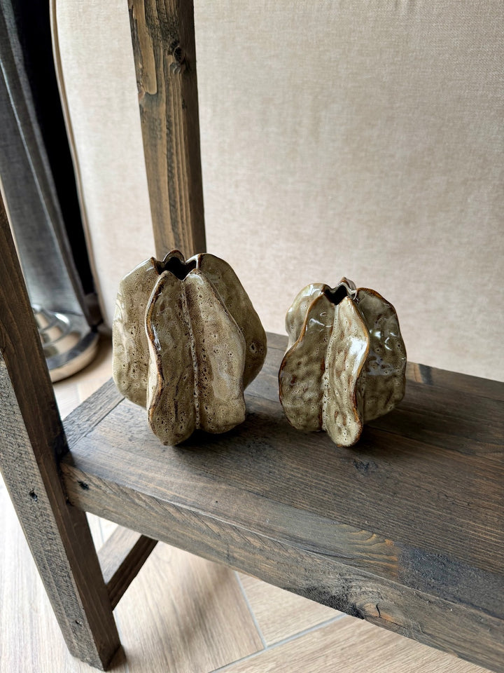 moderne woonaccessoires set in natuurlijke tinten op houten wandplank