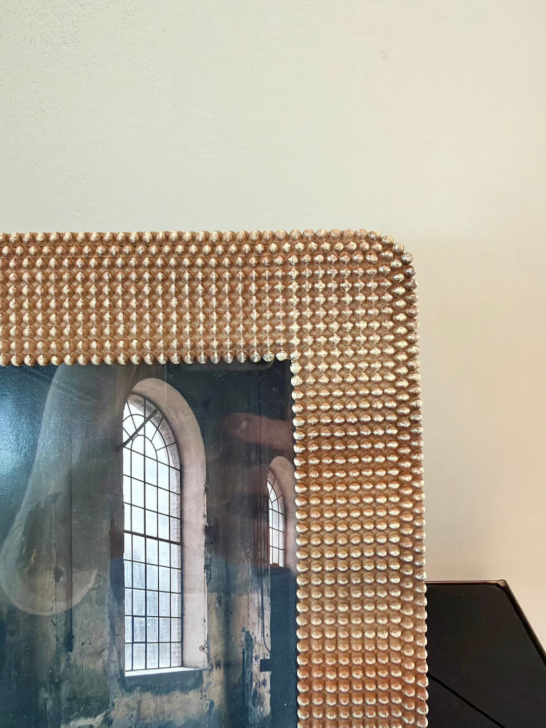 Detail van de bruine fotolijst met glanzend bolletjesreliëf