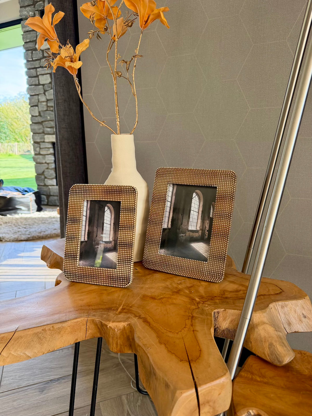 Set bruine fotolijsten gestyled met een vaas op een houten tafel