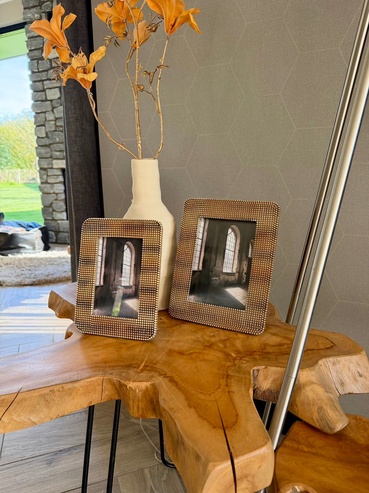 Set bruine fotolijsten gestyled met een vaas op een houten tafel