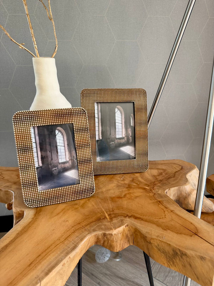 Bruine fotolijsten in twee formaten op een houten tafel