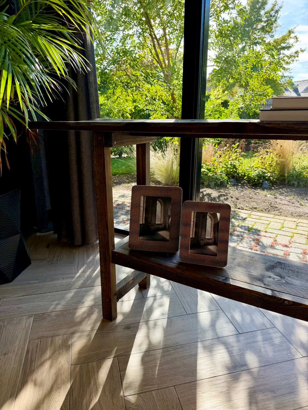 Sfeerfoto van bruine fotolijsten samen op een houten wandtafel