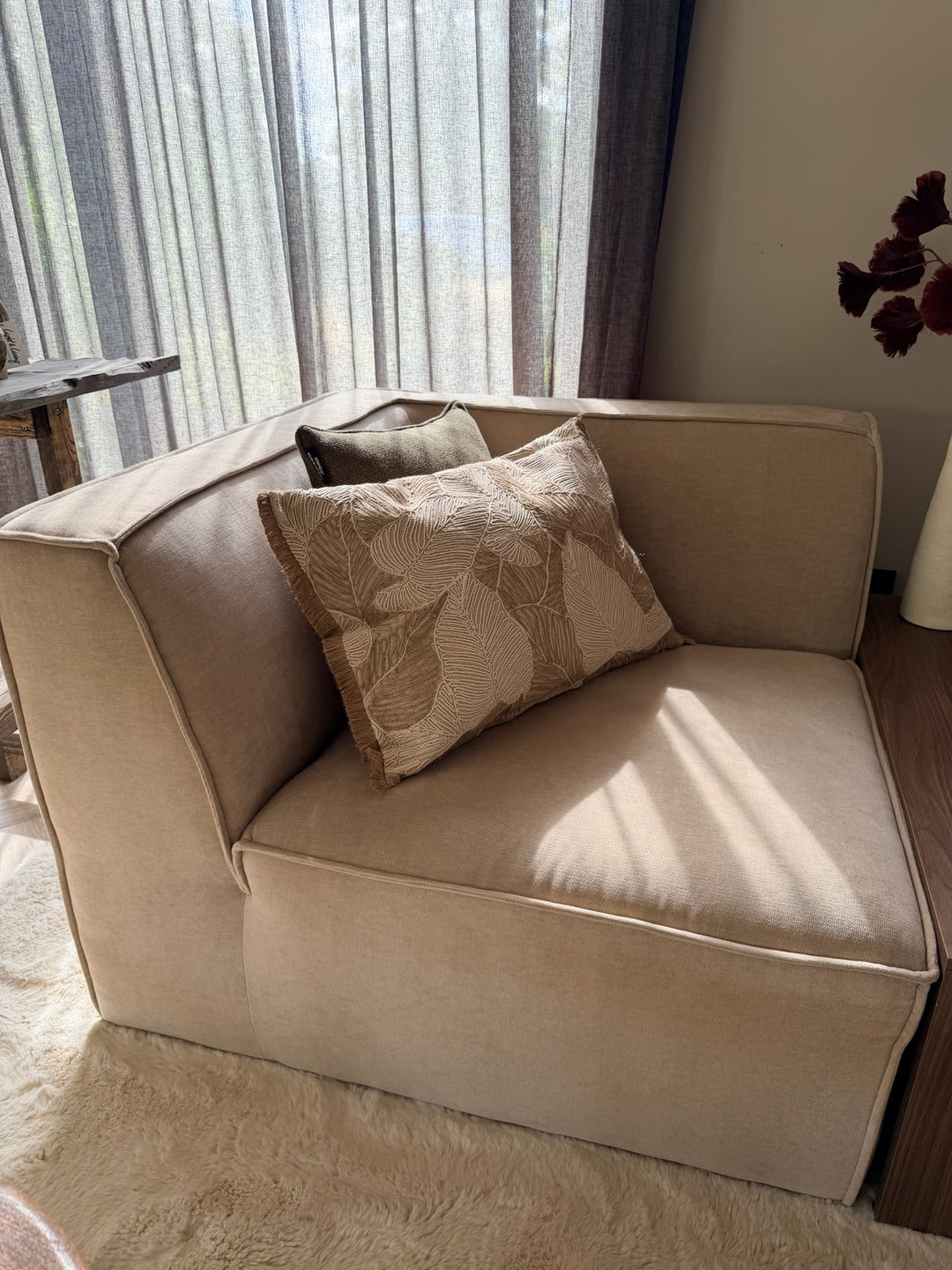 Naturel sierkussen Palm Leaf 40x60 cm met geborduurd bladmotief op beige bank