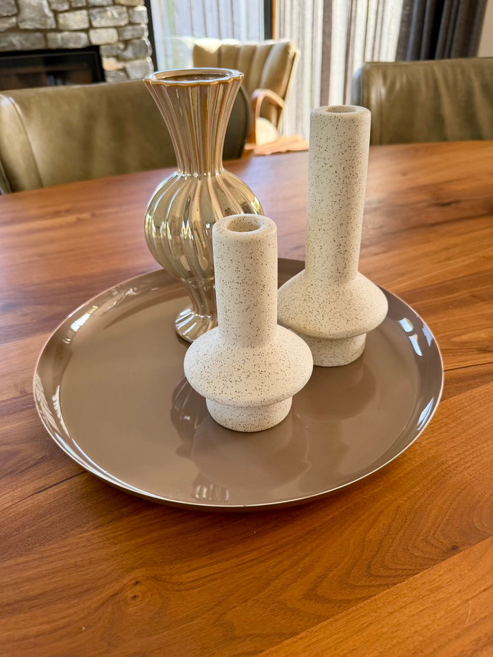 Taupe decoratieplateau gestyled met een vaas en zandkleurige kandelaars