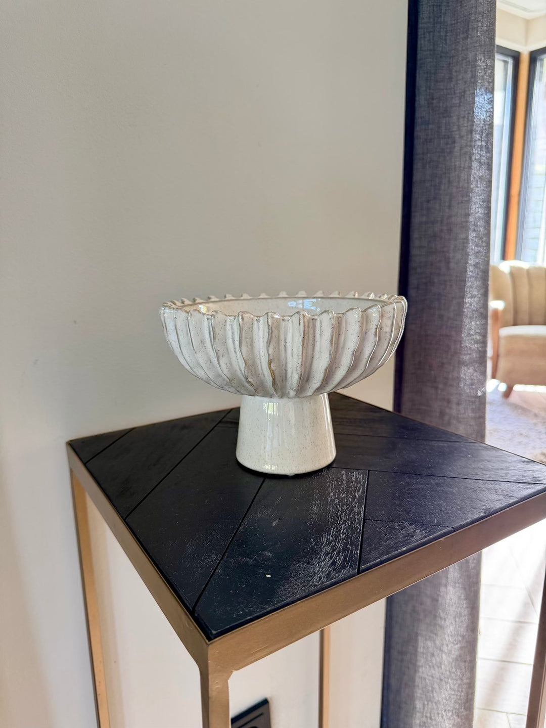 Zijaanzicht van beige keramieken decoratieschaal op voet