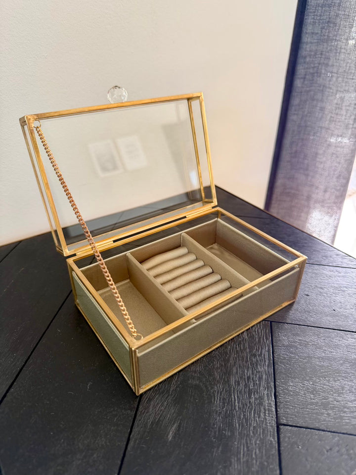Geopend sieradendoosje met goudkleurig metalen frame, ringrollen en twee zijvakken