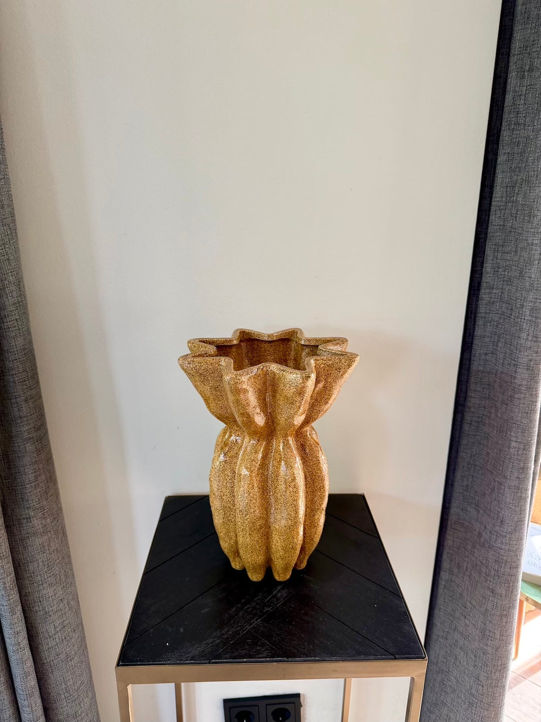Bovenaanzicht van de hoge bruine vaas met golvende opening
