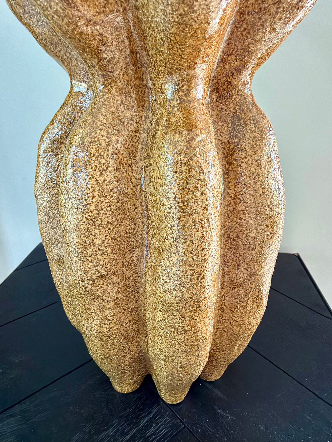 Detail van het golvende reliëf en de gemêleerde bruine afwerking