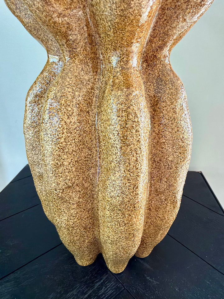 Detail van het golvende reliëf en de gemêleerde bruine afwerking